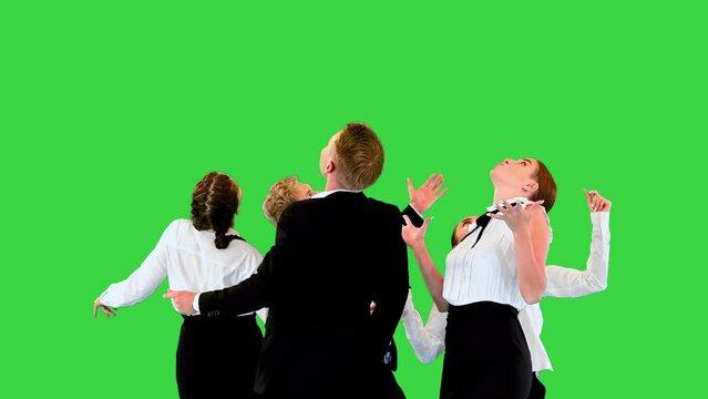 Carefree office workers perform weird round dance, looking up on a Green Screen, Chroma Key.