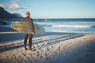 Surfer, elderly and beach for wellness, fitness and health to surf on adventure in summer. Senior,...