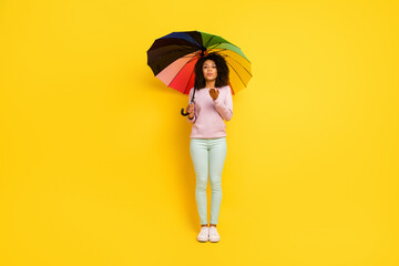 Full body photo of young pretty woman send air kiss romantic hold parasol isolated over yellow color background © Tetiana