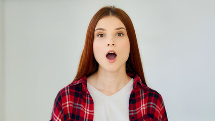 Surprised ginger girl student teenager feel good shock admiration female face excited winner says wow positive reaction holds head by hands successful result millennial young woman win lottery prize - obrazy, fototapety, plakaty