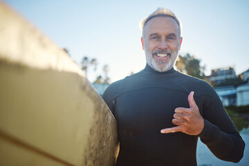 Beach, surf board and a happy elderly surfer man with hand sign and smile. Freedom, water sports...