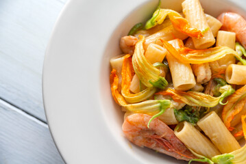 Piatto di saporita pasta con gamberi e fiori di zucca, cibo italiano 