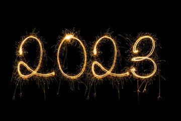 Obraz na płótnie Canvas Happy New Year 2023. Sparkling burning text Happy New Year 2023 isolated on black background. Beautiful Glowing golden overlay object for design holiday greeting card