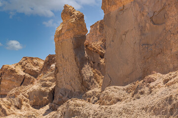 Fototapeta na wymiar Rock salt column on Mount Sodom on coast of Dead Sea in Israel. Traditionally perceived as petrified wife of Lot. Beautiful landscape with mountains against the blue sky. Landscape of the desert