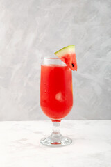 Watermelon smoothie or watermelon iced punch. Refreshing summer drink on grey background. Selective focus