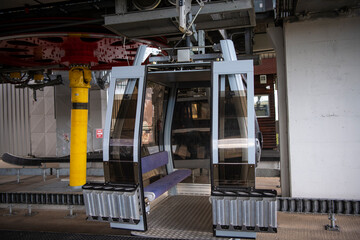 Cable car machinery station high above mountain. Metal cable and moving rollers on platform for funicular mechanism. Suspended glass cabin closeup. Mountain Zlatibor, Serbia 07.09.2022