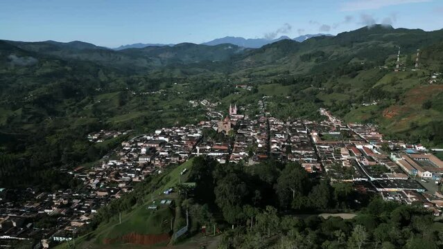 Aerial Drone Top Notch Flying Above Jerico Colombia Colonial Valley Town, Church View in Between Green Mountain Chain and Houses near Medellin