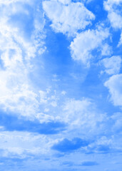 White clouds in a blue sky. Vertical snapshot