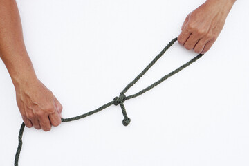 Closeup hands hold rope with knot on white background. Concept : Tying rope knots in daily life,...