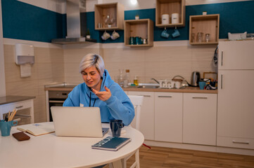 Woman on a video call with colleagues while using laptop and working from home