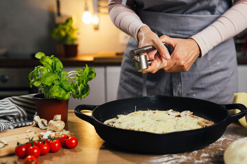 woman preparing home made pizza adding garlic