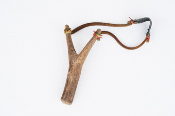 Handmade wooden slingshot,  a Y-shaped stick with elastic between the arms; used to propel small stones  Thai traditional weapon that use to shoot birds, fish , for fight  game or other purposes.     
