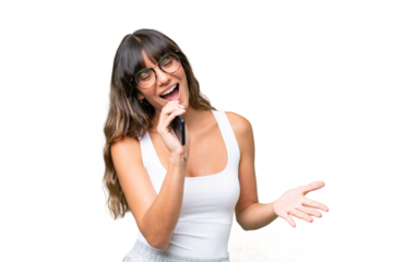 Young caucasian woman over isolated background using mobile phone and singing