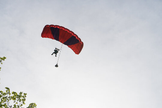 Parapente rouge et noir qui va bient&ocirc;t atterrir
