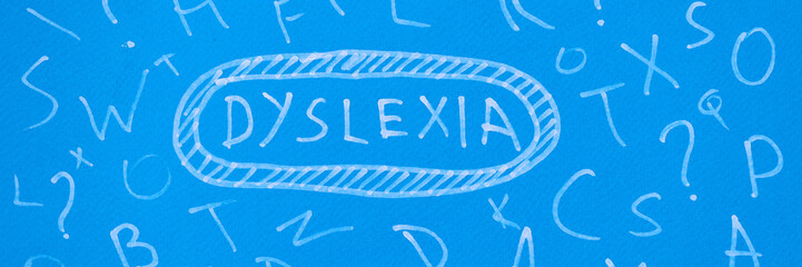 Word dyslexia is written on blue background among different letters closeup background - obrazy, fototapety, plakaty
