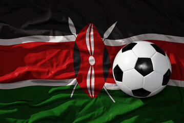 Naklejka premium vintage football ball on the waveing national flag of kenya background. 3D illustration