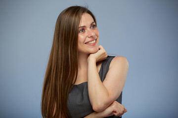 Smiling woman with long hair leaned on hands looking away, isolated portrait on blue background
