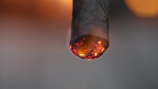Toasting the foot of a cigar in front of a Carmel Patio Garden fireplace.