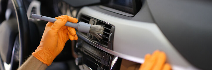 Mechanic cleaning air duct of cars with brush closeup