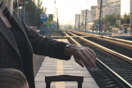 Train waiting concept. family waiting for the arrival of the train on the platform.woman looking at her wristwatch. the image shows a close-up of a woman's hand with a wristwatch