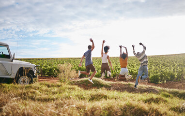 Jump, freedom and friends in a field in nature while on a summer road trip vacation in the countryside. Group, travel and happy people with energy on a outdoor holiday break in south africa.