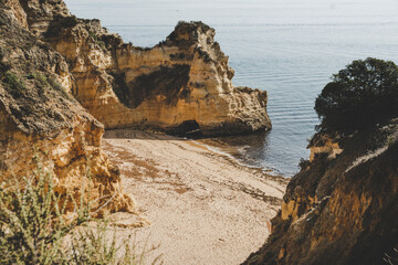 Empty and abandoned beach surrounded by cliffs on the coast of Algarve near Lagos.