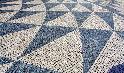 Pavement with black and white triangular pattern with Portuguese stones on a square in Lisbon, Portugal, Europe