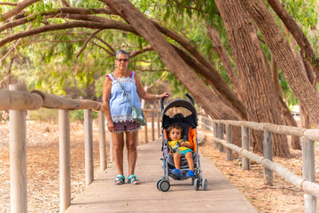 An elderly lady with her grandson walking on the path of the Lagunas de la Mata Natural Park in Torrevieja, Alicante