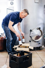 Man preparing craft beer from brewery for shipment.