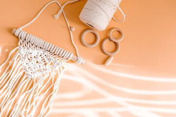 Macrame accessories on beige background. Creative hobby concept. Top view