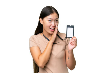 Young Asian woman with ID card over isolated background whispering something