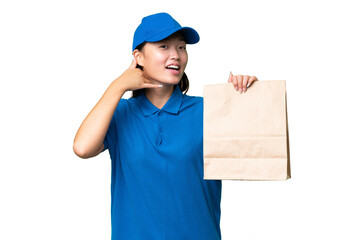 Young Asian woman taking a bag of takeaway food over isolated background making phone gesture. Call me back sign