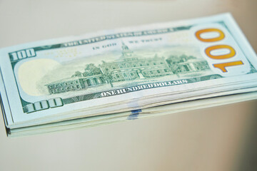 American currency dollars in hundred-dollar bills, reflected in the mirror. The concept of doubling payments or the illusion of wealth.