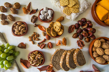 Table with a variation of autumn fruits. Background with fruit, nuts and pumpkin. All Saints Day.