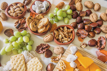 Table with a variation of autumn fruits. Background with fruit, nuts and pumpkin. All Saints Day.