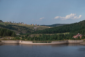 Obraz premium Scenic aerial view of lake dam with forest in background on Zlatibor mountain, Serbia 07.09.2022