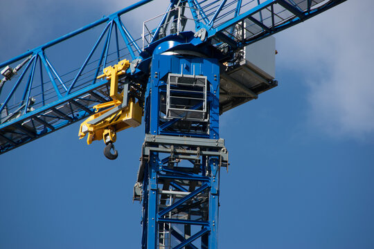 bright construction crane with blue background and operator booth