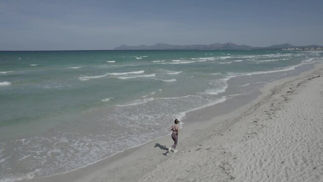 Chica corriendo por la playa drone, (Formato D-log para edici&oacute;n profesional)	
