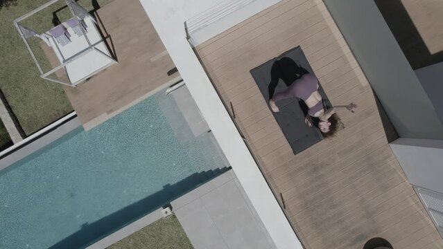 Mujer practica yoga en terraza de casa drone, (Formato D-log para edici&oacute;n profesional)	
