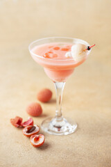 Delicious lychee cocktail in Margarita glass and fresh fruits on  table.