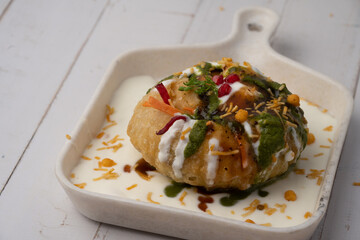 Rajasthani Shahi Raj-Kachori, stuffed with potato and sprout filling. served with curd, chutney and sev in a plate