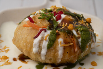 Rajasthani Shahi Raj-Kachori, stuffed with potato and sprout filling. served with curd, chutney and sev in a plate