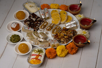 Mix indian sweets like kaju roll dryfruits barfi mango peda served in a plate
