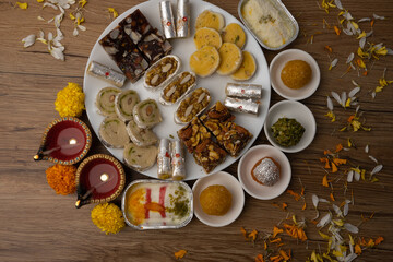 Mix indian sweets like kaju roll dryfruits barfi mango peda served in a plate