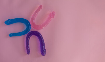 multicolored silicone sex toys on a pink background. Erotic toy for fun. Diffrent anal butt plugs. Diffrent anal butt plugs. Banner with space for text