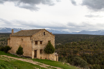 Fototapeta na wymiar Casona en la villa de Pedraza. Al fondo se pueden ver las montañas nevadas de la sierra del Guadarrama. Segovia, Castilla y León, España.