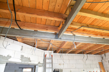 Construction of a residential building. Metal beam supports wooden ceiling of the second floor