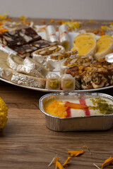 Mix indian sweets like kaju roll dryfruits barfi mango peda served in a plate