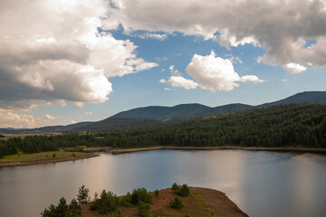 Aerial view of golden pine forest and lake at Zlatibor mountain in Serbia, shot from gondola or cable car. Scenic view of Zlatibor mountain.