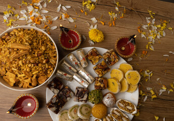 Mix indian sweets like kaju roll dryfruits barfi mango peda served in a plate